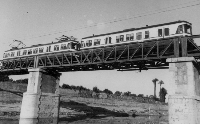 Ferrocarril de Valencia á Villanueva de Castellón , unidad electrica sobre el puente del barranco de Xiva , en Paiporta, c.1970, Archivo FGV